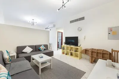 a living room with a couch and a tv at ALiving Cozy Studio with Balcony I Marina Pearl- 407 in Dubai