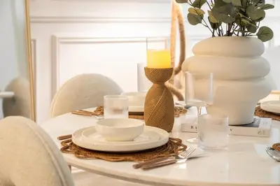 a dining room table with a candle and a vase at Sunset serenity - Urban Oasis Business Bay in Dubai