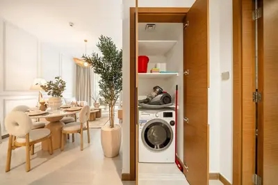 a kitchen and dining room with a washing machine in a room at Sunset serenity - Urban Oasis Business Bay in Dubai