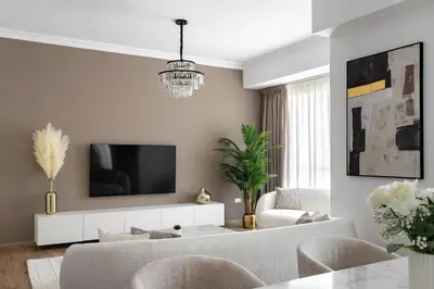 a living room with a couch and a tv on a wall at 1 bedroom Apartment in JBR in Dubai