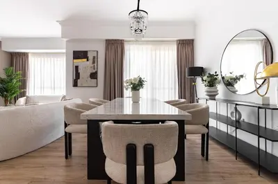 a living room with a table and chairs and a couch at 1 bedroom Apartment in JBR in Dubai