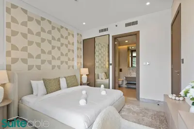 a bedroom with a white bed and a bathroom at Stunning 1 Bedroom with Burj Khalifa view in Dubai