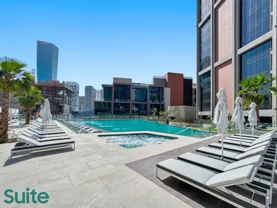 a swimming pool with lounge chairs and a building at Stunning 1 Bedroom with Burj Khalifa view in Dubai