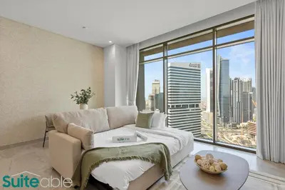a living room with a couch and a large window at Stunning 1 Bedroom with Burj Khalifa view in Dubai