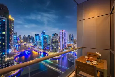 a balcony with a view of a city at night at High floor Marina Views Walk to Beach JBR & Mall in Dubai