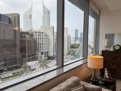 a living room with a view of the city from windows at ASHRI Stylish African-Inspired Studio in DIFC in Dubai