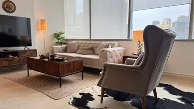 a living room with a couch and a chair at ASHRI Stylish African-Inspired Studio in DIFC in Dubai