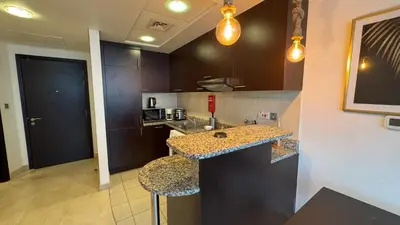 a kitchen with a counter and a sink in a room at ASHRI Stylish African-Inspired Studio in DIFC in Dubai