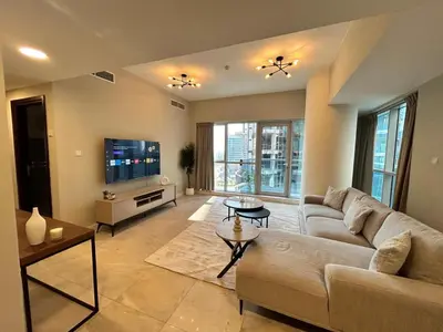 a living room with a couch and a tv at Spacious 1BHK Apartment, Near City centre in Dubai