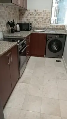 a kitchen with a dishwasher and a washer at Spacious 1BHK Apartment, Near City centre in Dubai
