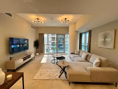 a living room with a couch and a tv at Spacious 1BHK Apartment, Near City centre in Dubai