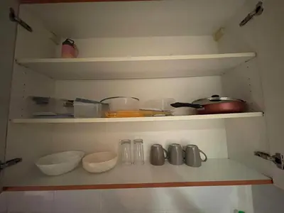 a shelf with bowls and utensils in a kitchen at Ultra Luxury Chic Studio in JLT in Dubai