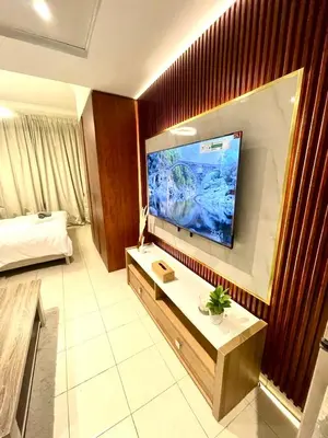 a hotel room with a large flat screen tv on the wall at Ultra Luxury Chic Studio in JLT in Dubai
