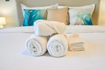 a pile of towels sitting on top of a bed at Cozy Studio with Balcony in Azizi Riviera and 10 Mins to Burj Khalifa in Dubai