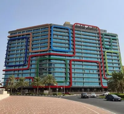 a large office building with red and blue windows at Dubai Silicon Oasis Holiday Homes in Dubai