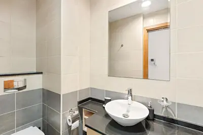a bathroom with a sink and a toilet and a mirror at Elegant 1BR in Ocean Heights in Dubai