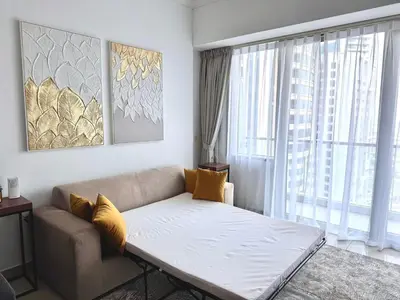 a living room with a couch and a large window at Elegant 1BR in Ocean Heights in Dubai