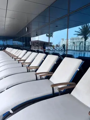 a row of white lounge chairs in a building at Elegant 1BR in Ocean Heights in Dubai