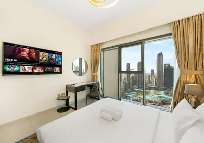 a bedroom with a bed and a desk and a window at Luxury 3 BR Full Burj Khalifa and Fountain View in Dubai