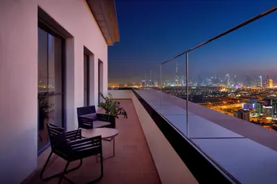 a balcony with a view of a city at night at Hyatt Regency Creek Heights Residences in Dubai