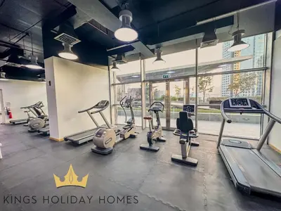 a gym with cardio machines and a sign that says kings holiday homes at Central Park towers Difc suite kings in Dubai
