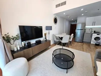 a living room with a television and a table and chairs at Marina Water Residence in Dubai