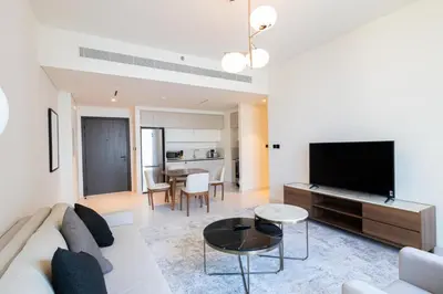 a living room with a couch and a flat screen tv at Marina Vista - Elegant 1BR- 2606 in Dubai
