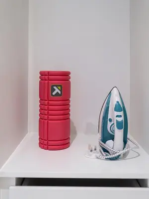 a shelf with a stack of red cups and a figurine at Downtown views II in Dubai