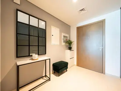 a hallway with a door and a green ottoman at Downtown views II in Dubai