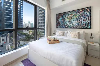 a bedroom with a large white bed and a large window at Frank Porter - Bay Central in Dubai