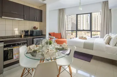 a kitchen and living room with a table and a bed at Frank Porter - Bay Central in Dubai
