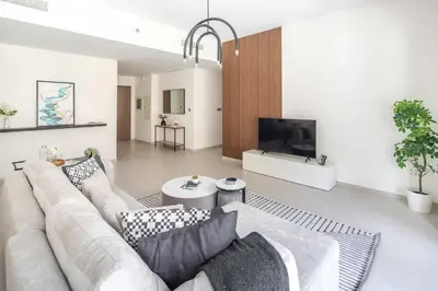 a living room with a couch and a flat screen tv at Frank Porter - Grande Signature in Dubai