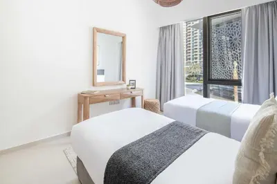 a bedroom with two beds and a mirror and a window at Frank Porter - Grande Signature in Dubai