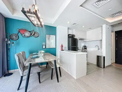 a kitchen with a table with a motorcycle on the wall at 3 Bed - Aquilegia, Damac 2 in Dubai