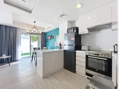 a kitchen with white cabinets and a stove top oven at 3 Bed - Aquilegia, Damac 2 in Dubai