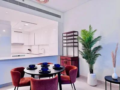 a dining room with a table and chairs and a kitchen at Canal Front - Luxury 2BR Stay in Al Wasl in Dubai