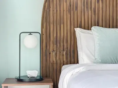 a bed with a wooden headboard and a lamp on a table at One Residence - Retreat in Dubai