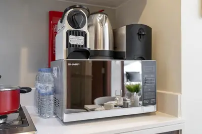 a microwave oven sitting on a counter next to a stove at Stunning Burj View - Cozy 2BR - 5 min Dubai Mall in Dubai