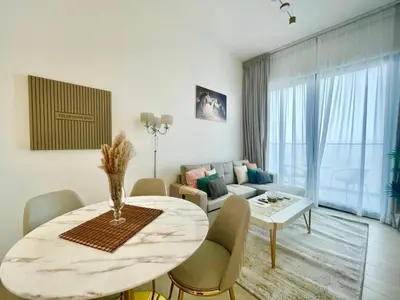 a living room with a table and a couch at Chic & Serene 1br Apt Balcony, Pool & Parking in Dubai