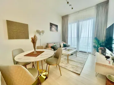 a living room with a table and chairs and a living room at Chic & Serene 1br Apt Balcony, Pool & Parking in Dubai