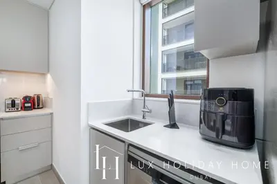 a kitchen with a sink and a microwave at LUX The Dubai Creek Beach Suite in Dubai