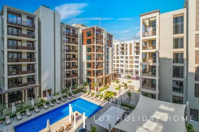 an image of an apartment complex with a swimming pool at LUX The Dubai Creek Beach Suite in Dubai