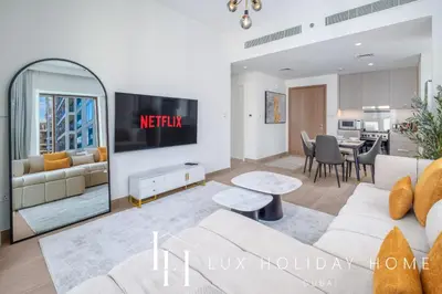 a living room with a couch and a kitchen at LUX The Dubai Creek Beach Suite in Dubai