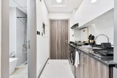 a white kitchen with a sink and a stove at Stunning 1BR APT in Rukan with Gym and Pool in Dubai
