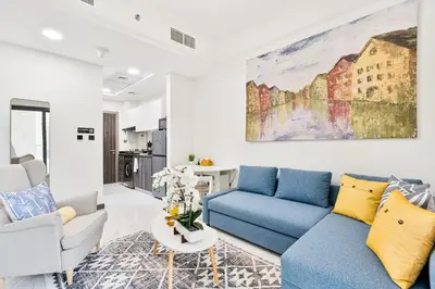 a living room with blue couches and a painting on the wall at Stunning 1BR APT in Rukan with Gym and Pool in Dubai