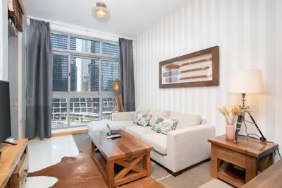 a living room with a couch and a table at Vacay Lettings - Stylish 1 Bedroom Apartment with Marina View, Dubai Marina in Dubai