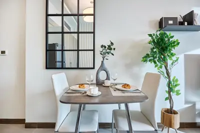 a dining room with a wooden table and white chairs at Luxury Studio - SOL BAY Tower - Business Bay by Stayfinity in Dubai