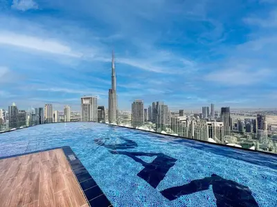 a large swimming pool on top of a skyscraper at Stunning Burj View - High Infinity Pool - Cozy 2BR in Dubai