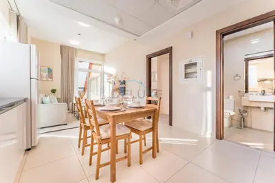 a kitchen and dining room with a table and chairs at Steps from Retail Stores and Sports Facilities 1BR, Binghatti Gateway, Al Jaddaf by Deluxe Holiday Homes in Dubai