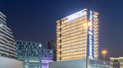 a tall building with lights on it at night at Steps from Retail Stores and Sports Facilities 1BR, Binghatti Gateway, Al Jaddaf by Deluxe Holiday Homes in Dubai